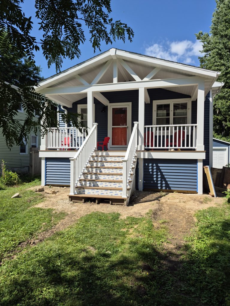 An "after" image of a house with a beautiful custom covered front porch.